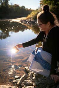 Joanne Robertson kneeling by the river